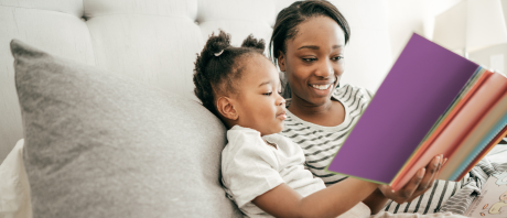 A mother and child read a book together