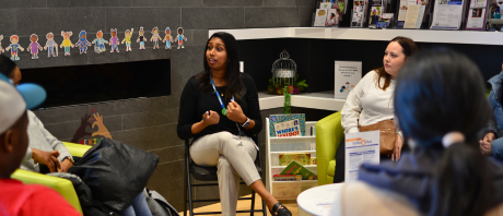 A group of women sitting in a circle with one woman speaking and the others listening.