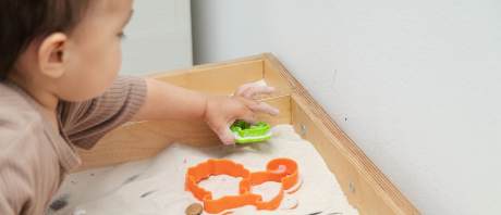 A child plays with a sand table.