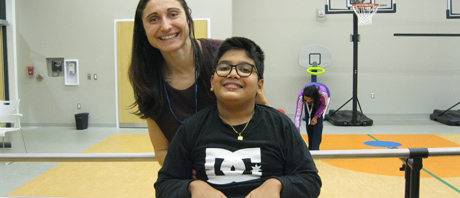 Young person and staff member in a gym