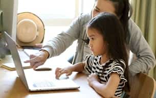 Mom and daughter look at computer