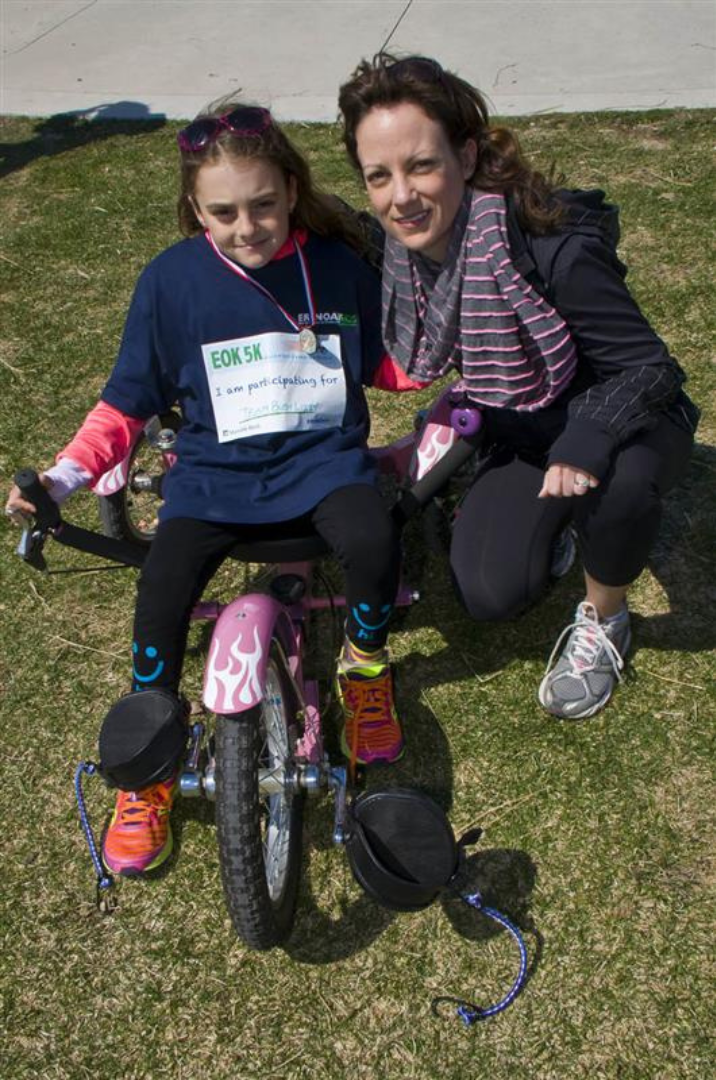 Lizzy on a bike beside her mom Angela at the 2014 EOK 5K