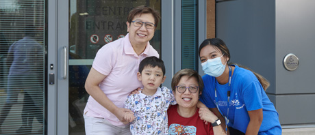 Two parents and a child and a respite worker smiling