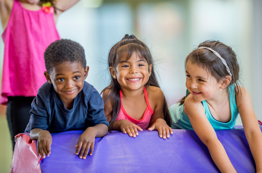 three children play on a mat