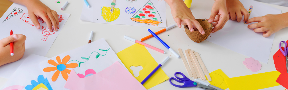 Kids' hands doing crafts at a table