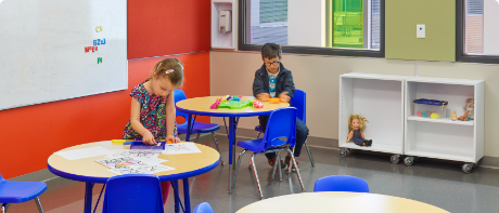 Two kids sitting at a table, learning