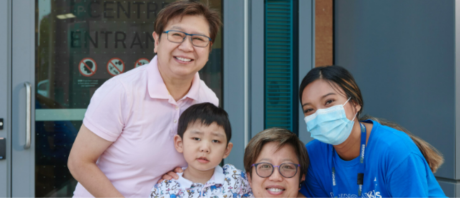 A family poses with an ErinoakKids staff member