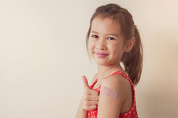 girl with bandaid and thumbs up